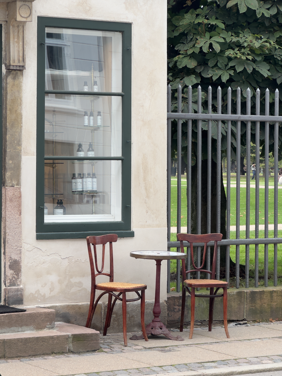 To stole og et cafébord ved et grønt vindue i København