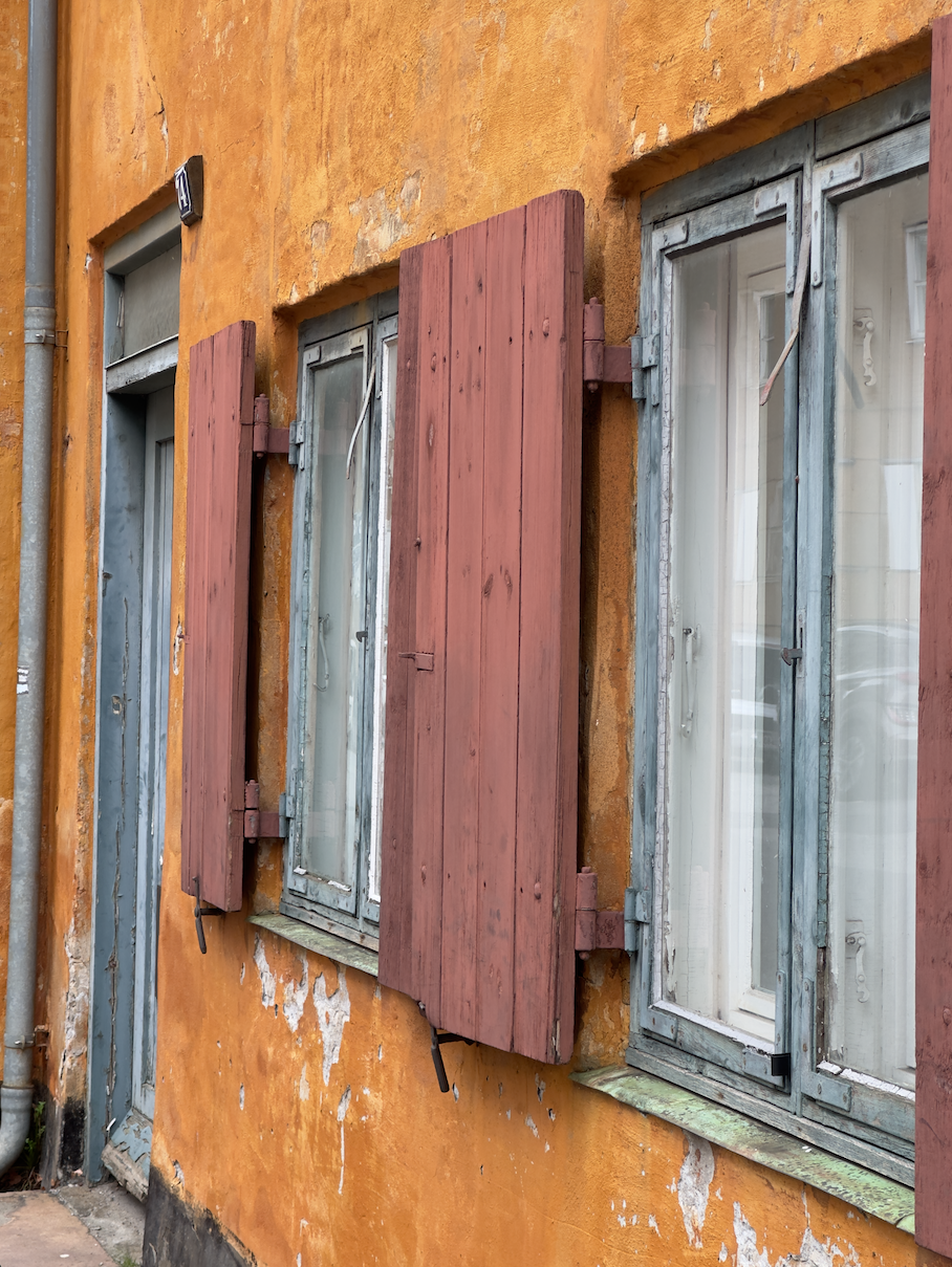 Orange facade med træskodder og blågrå vinduer i Nyboder