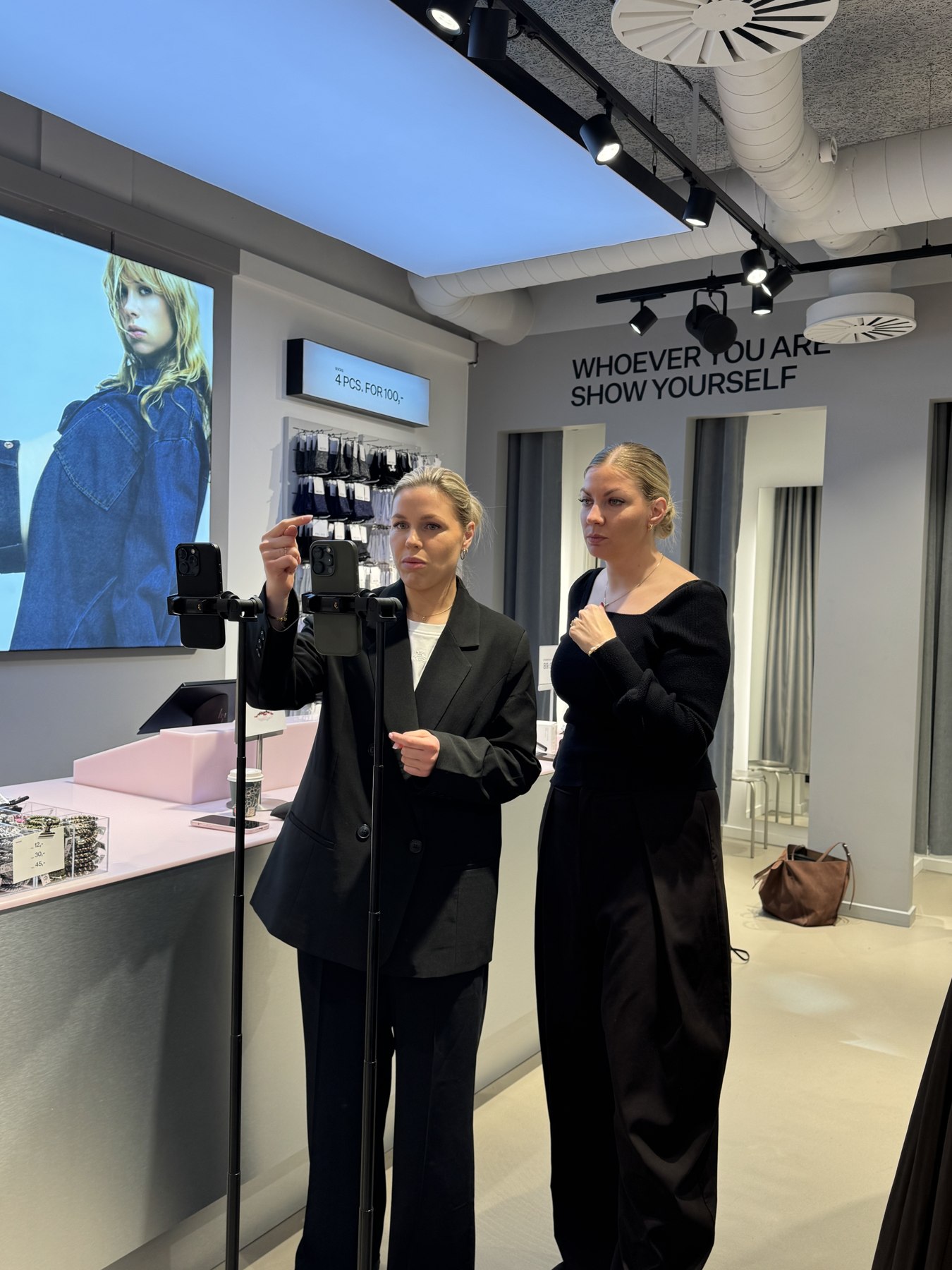To fra produktionen klargør telefoner på stativer i butikken